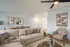 Inviting modern living room with elegant beige sofa, stylish abstract art, and a cozy dining area. Perfect for relaxation and entertainment.