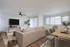 Inviting modern living and dining area with cozy beige sofa, stylish decor, and abundant natural light.