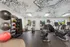 Modern fitness center with state-of-the-art cardio machines, vibrant exercise balls, and scenic views from large windows.