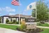 Welcoming ReNew Waltham leasing office with lush greenery and vibrant flags, offering a modern and inviting community atmosphere.