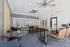 Modern communal lounge area with sleek furniture, high ceiling, and ample natural light.