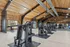 Spacious modern gym with wooden ceiling, state-of-the-art equipment, and natural light for an energizing workout experience.