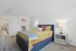 Inviting bedroom with plush bed, vibrant decor, and ample closet space in a modern apartment.
