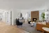 Inviting living room with modern decor, featuring a cozy fireplace, stylish furniture, and natural light from large windows.