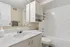 Bright and elegant bathroom with sleek quartz countertop, spacious vanity, and modern bathtub.
