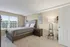 Bright, spacious bedroom with large window, modern decor, and cozy bedding creates a welcoming atmosphere.