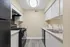 Contemporary kitchen with sleek black appliances, ample cabinetry, and modern lighting, perfect for culinary creativity.