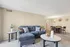 Contemporary living space with a plush gray sofa, elegant decor, and a cozy dining area, ideal for modern comfort.