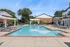 Inviting outdoor pool area with stylish loungers, elegant pergolas, and vibrant blue accents perfect for relaxation.