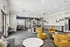 Inviting community lounge with stylish decor, featuring plush yellow seating, modern shelving, and ample natural light.