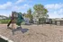 Inviting playground area featuring a vibrant green slide, swings, and rustic play structures, set against a backdrop of lush greenery, perfect for family enjoyment.