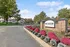 Inviting apartment entrance featuring vibrant landscaping and a welcoming brick sign at the ReNew community.