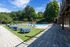 Luxurious outdoor pool area surrounded by lush greenery, featuring comfortable lounge chairs and inviting blue round daybeds under a clear blue sky.
