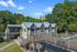Charming apartment complex surrounded by lush greenery, featuring unique architectural design and spacious outdoor walkways.