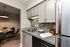 Modern kitchen with sleek granite countertops, stylish backsplash, and integrated appliances, leading to a cozy dining area with elegant decor.