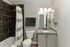 Elegant bathroom with sleek granite countertops, modern fixtures, and stylish tiled shower.