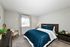 Cozy bedroom with a warm wooden bed frame, elegant teal bedding, and charming decor showcasing inviting ambiance and natural light.