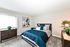 Chic and cozy bedroom with a modern dark wood bed, stylish blue bedding, and elegant decor, perfect for relaxation.