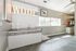 Chic pet-friendly space with tiled walls, modern sink, and bold 'WOOF' sign, offering a stylish and welcoming atmosphere.