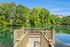 Tranquil dock overlooking lush greenery and calm waters, offering a serene retreat in a scenic environment.