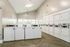 Bright and spacious laundry room equipped with modern washing machines and dryers, offering convenience and efficiency in your apartment living experience.