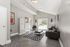 Modern apartment lounge with sleek gray flooring, stylish sofa, and large window letting in natural light.