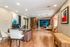 Modern open-concept office space featuring stylish wood flooring, elegant artwork, and a cozy seating area with a flat-screen TV.