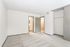 Bright spacious bedroom with plush carpeting, dual doors, and an open closet, perfect for comfortable living.