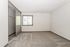 Bright and spacious bedroom with plush carpet, large closet, and sunlit window, perfect for comfort and relaxation.