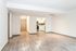 Modern open-plan living space with elegant flooring and a sleek kitchen featuring stainless steel appliances.