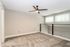 Modern and spacious loft area with plush carpeting and sleek ceiling fan, enhanced by natural light from stylish windows.