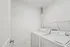 Bright, modern laundry room featuring a sleek washer and dryer set, with ample shelving for storage.
