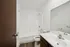 Elegant modern bathroom featuring a pristine white bathtub, sleek fixtures, and stylish wood accents.