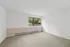 Bright, spacious room with plush carpet and a large window offering serene views, perfect for a cozy bedroom setting.