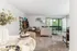 Bright, elegant living space featuring modern decor, lush greenery views from sliding glass doors, and a cozy, welcoming atmosphere.