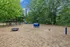 Inviting playground with vibrant blue and yellow slide, surrounded by lush greenery, ideal for family fun and outdoor activities.