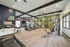 Modern fitness center with state-of-the-art equipment, vibrant leaf-patterned accent wall, and spacious workout area.