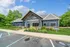 Inviting leasing center surrounded by lush greenery and colorful flowers, featuring modern architecture and accessible parking.