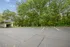 Beautiful outdoor parking area surrounded by lush green trees, offering tranquility and convenience.