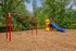 Inviting playground with vibrant slides, swings, and lush green surroundings for family fun and relaxation.