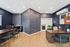 Modern office space featuring stylish abstract wallpaper, sleek wooden desks, and a cozy seating area, creating an inviting and professional environment.