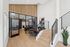 Modern interior office space with sleek glass walls, wooden flooring, and stylish staircase, offering a contemporary and inviting atmosphere.