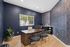 Chic home office with modern design, featuring stylish blue wallpaper, elegant desk setting, and natural indoor lighting.