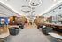 Luxurious apartment lobby with modern circular chandeliers, elegant seating areas, and natural wood accents, offering a sophisticated atmosphere.