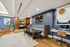 Elegant office lounge with modern decor, featuring a stylish wooden table, plush seating, and vibrant artwork, perfect for inspiring creativity.