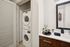 Chic apartment with in-unit Bosch washer and dryer set discreetly tucked into a sleek modern bathroom, featuring elegant decor and ample storage.