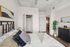 Modern bedroom featuring chic decor, elegant furnishings, and a cozy ambiance with open closet and view into the stylish kitchen.