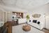 Bright and modern living space featuring an open-concept kitchen with sleek cabinetry, a cozy white sofa, stylish lighting, and chic decor elements.