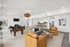 Luxurious and spacious living area featuring a cozy fireplace, elegant pool table, stylish seating, and a modern open kitchen with a chic bar counter.
