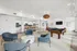 Luxurious open-concept living area with stylish blue chairs, cozy dining space, and modern kitchen. Features a pool table for entertainment and elegant lighting to enhance the ambiance.